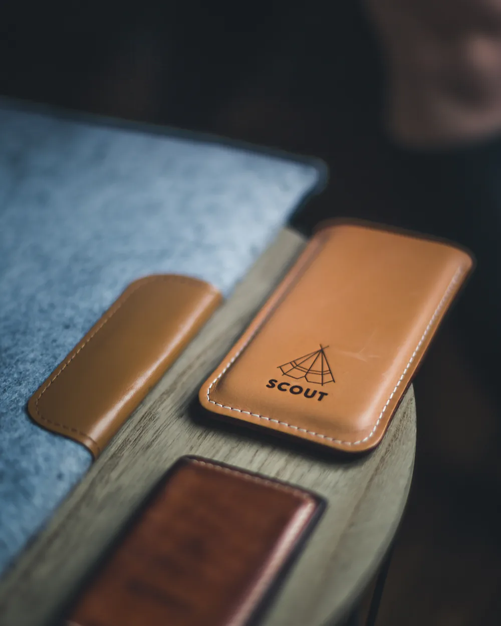 Slim leather sleeves and a card wallet arranged on a dark surface