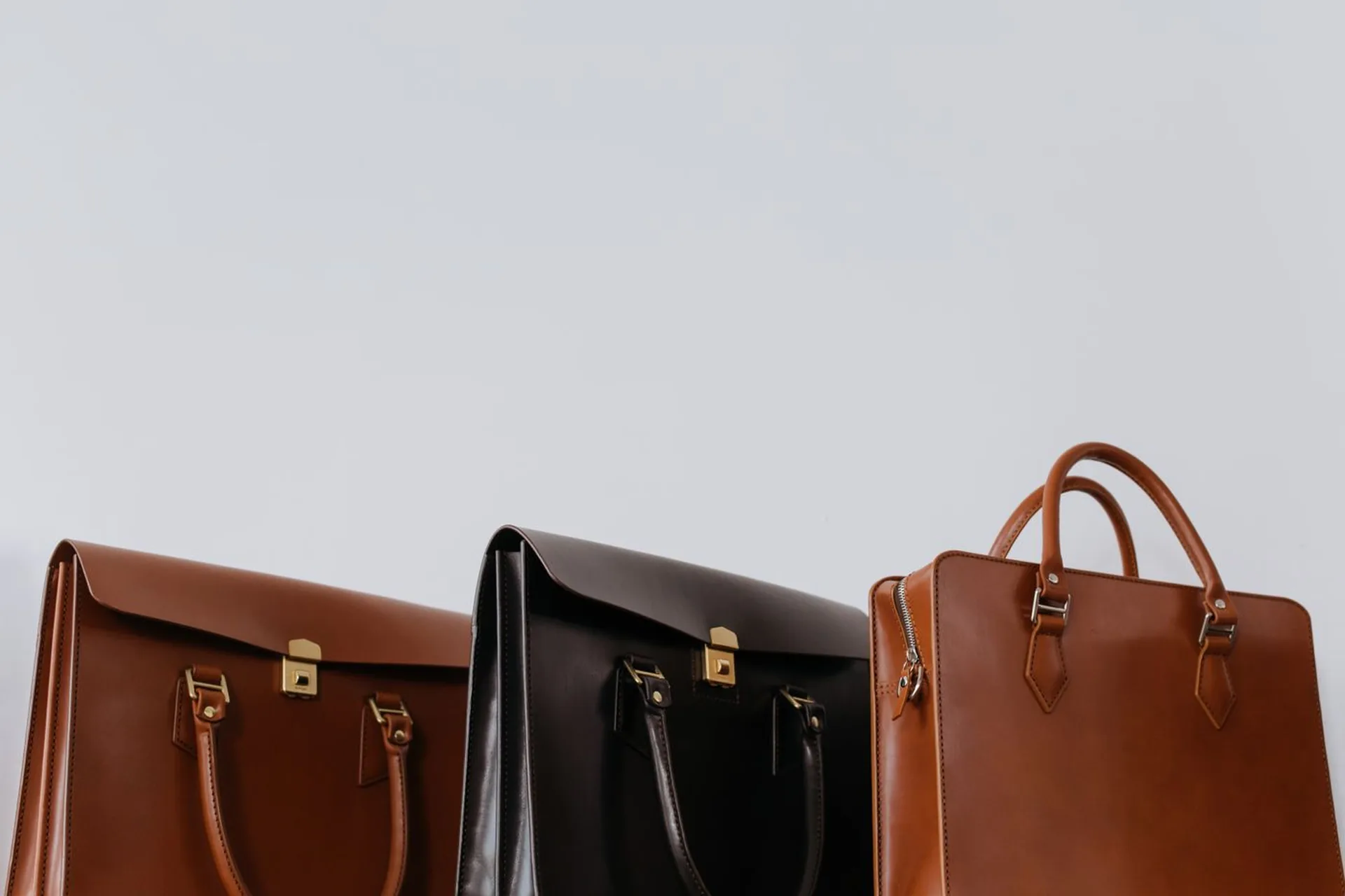 Three finished leather bags standing side by side