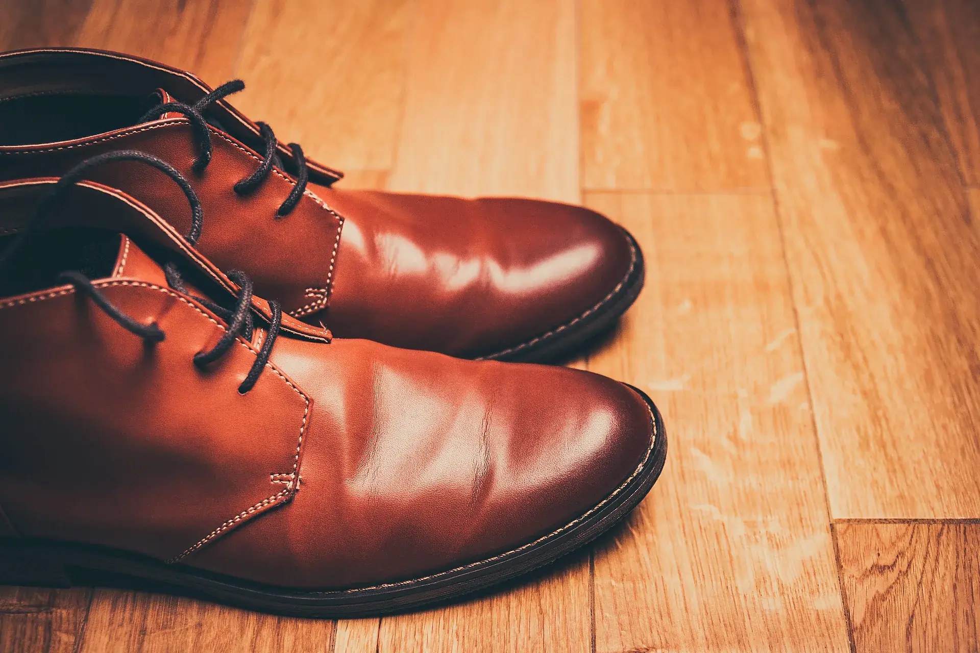 A pair of brown leather shoes on a wooden floor