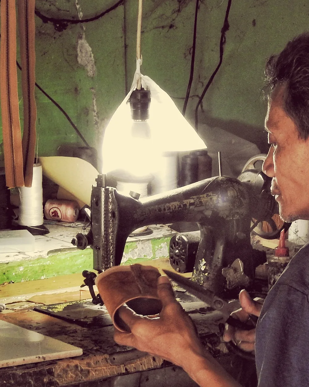 A machinist running a leather panel through the stitching machine
