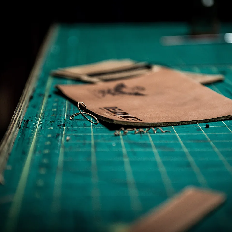 Leather panels being cut to pattern on the workroom bench