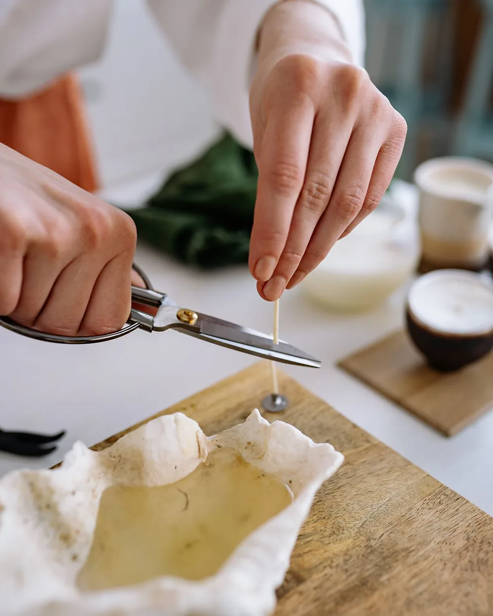 A pair of hands cutting handmade soap at a workshop table