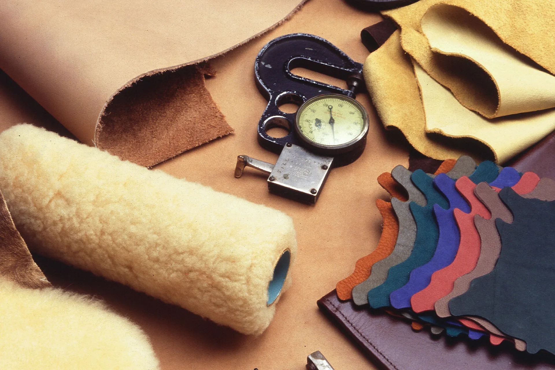 Hobby leathercraft tools and hide swatches laid out on a bench