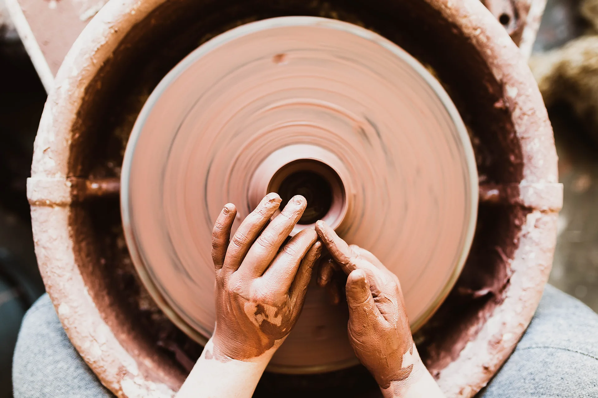 Hands at a potter's wheel during a family craft session