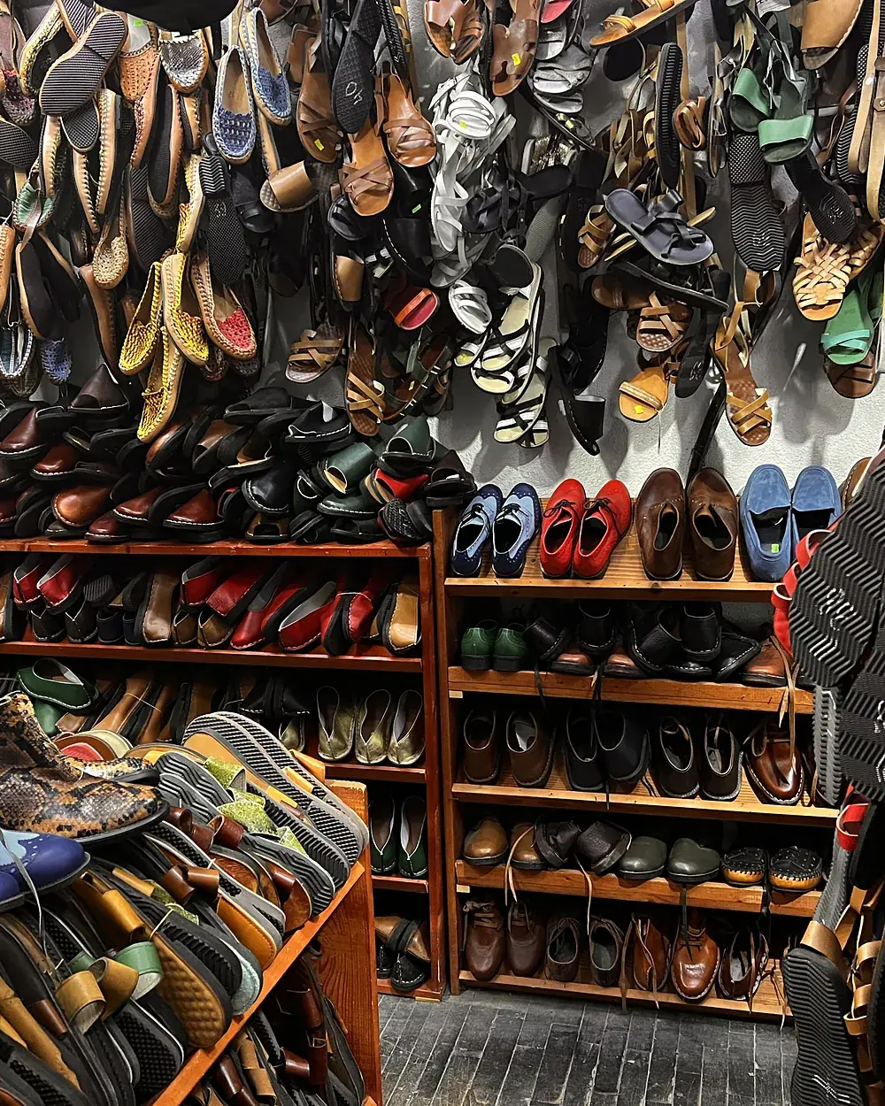 A leather footwear shop with sandals and shoes displayed wall to wall