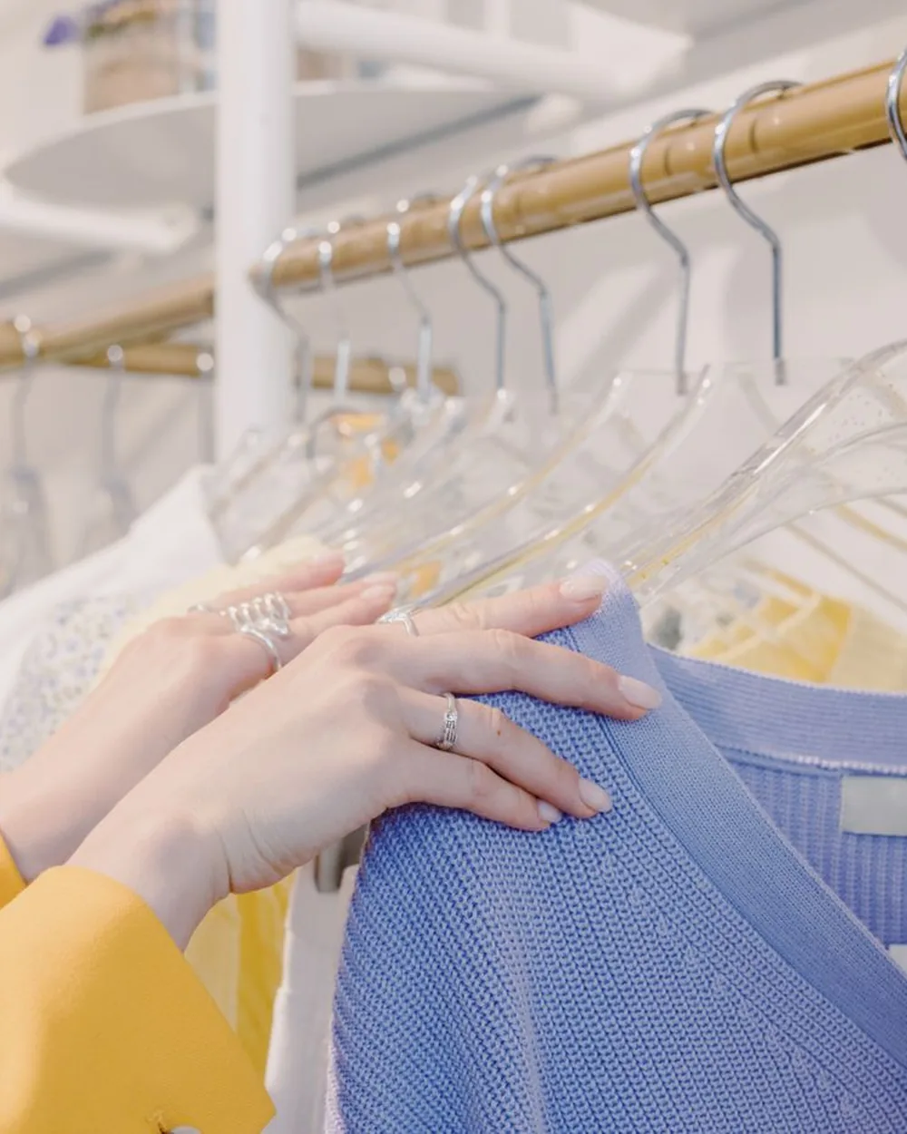 A customer looking through garments on a shop rail