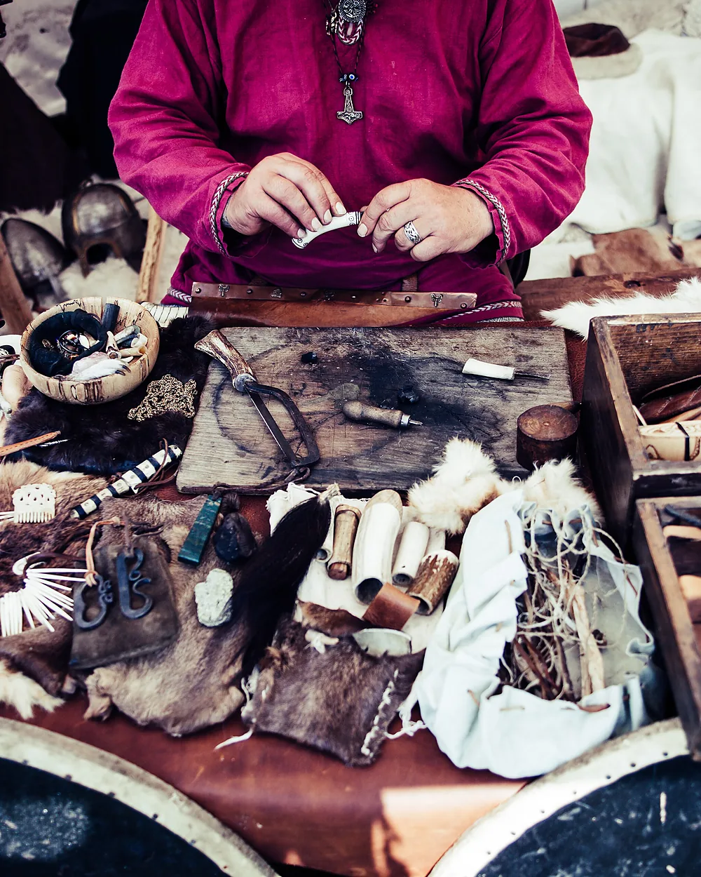 An artisan at a bench laid out with leather pieces and hand tools