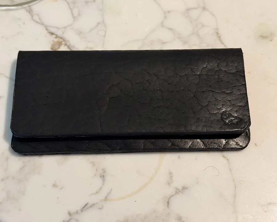 A hand-cut leather long wallet on a marble surface