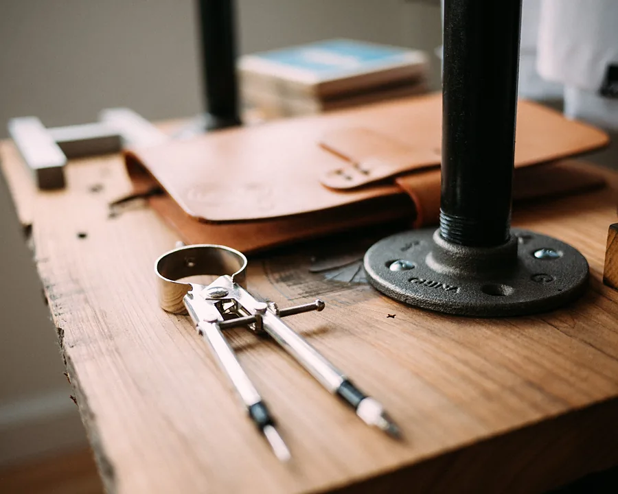 A guest saddle-stitching a leather panel at the workshop bench