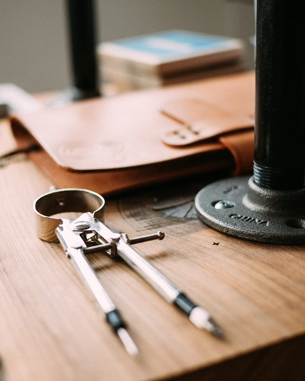 A leather strap and dividers laid out on the studio workbench
