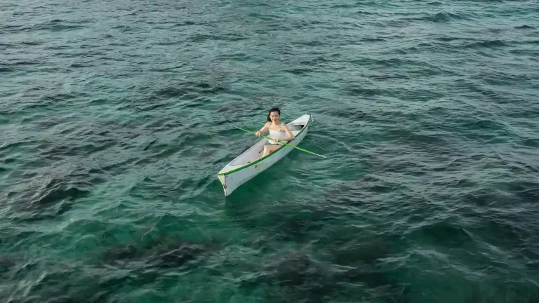 Solo traveller paddling a canoe in clear Indonesian water