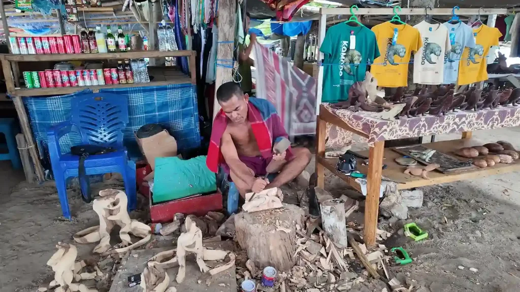 Craftsman hand-carving a wooden figure in Indonesia